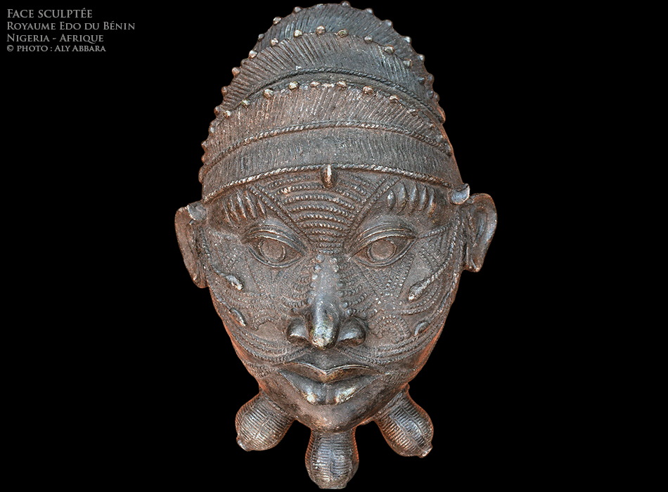 Art africain - Visage humain magnifié - Objet artistique métallique décoratif - Royaume de Bénin - Nigeria - Exemple 01