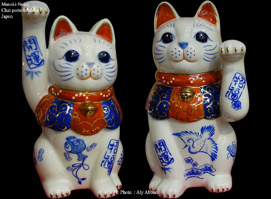 Deux Maneki-Neko blancs le premier lève sa patte de devant droite (version masculine) et le deuxième lève sa patte de devant gauche (version féminine)