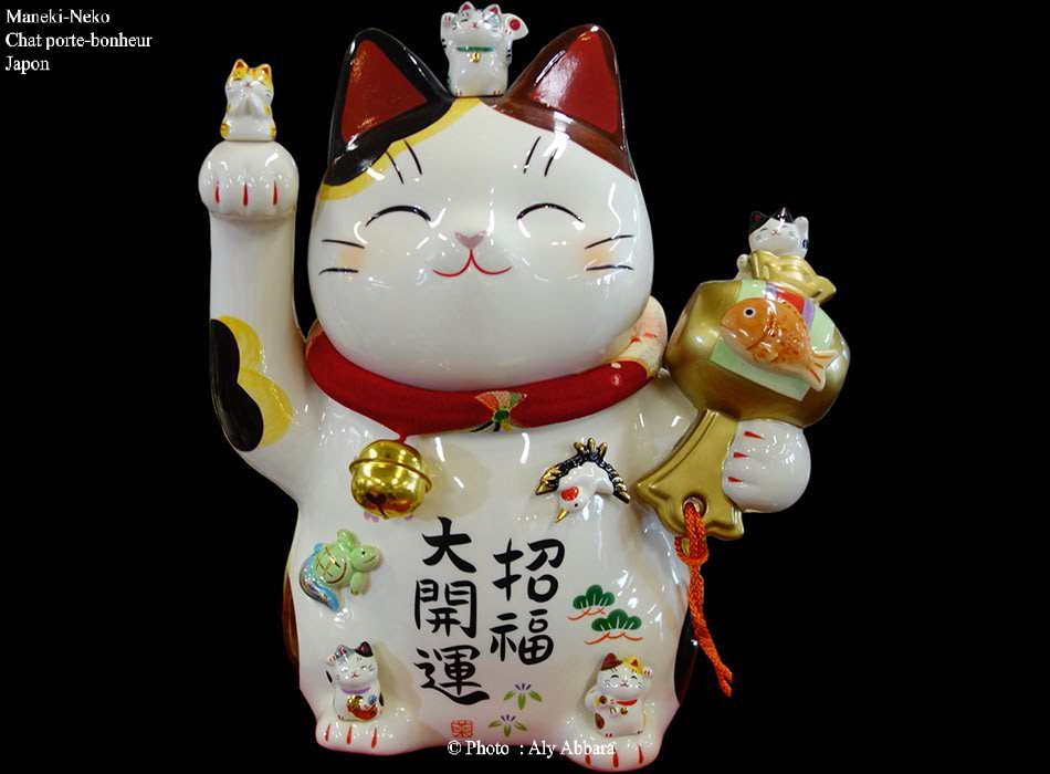 Maneki-Neko complexe composé de multiples chats blancs (un grand et des petits) tous portent un collier rouge à petite clochette
